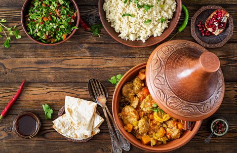 Traditional tajine dishes, couscous  and fresh salad  on rustic wooden table. Tagine lamb meat and pumpkin. Top view. Flat lay